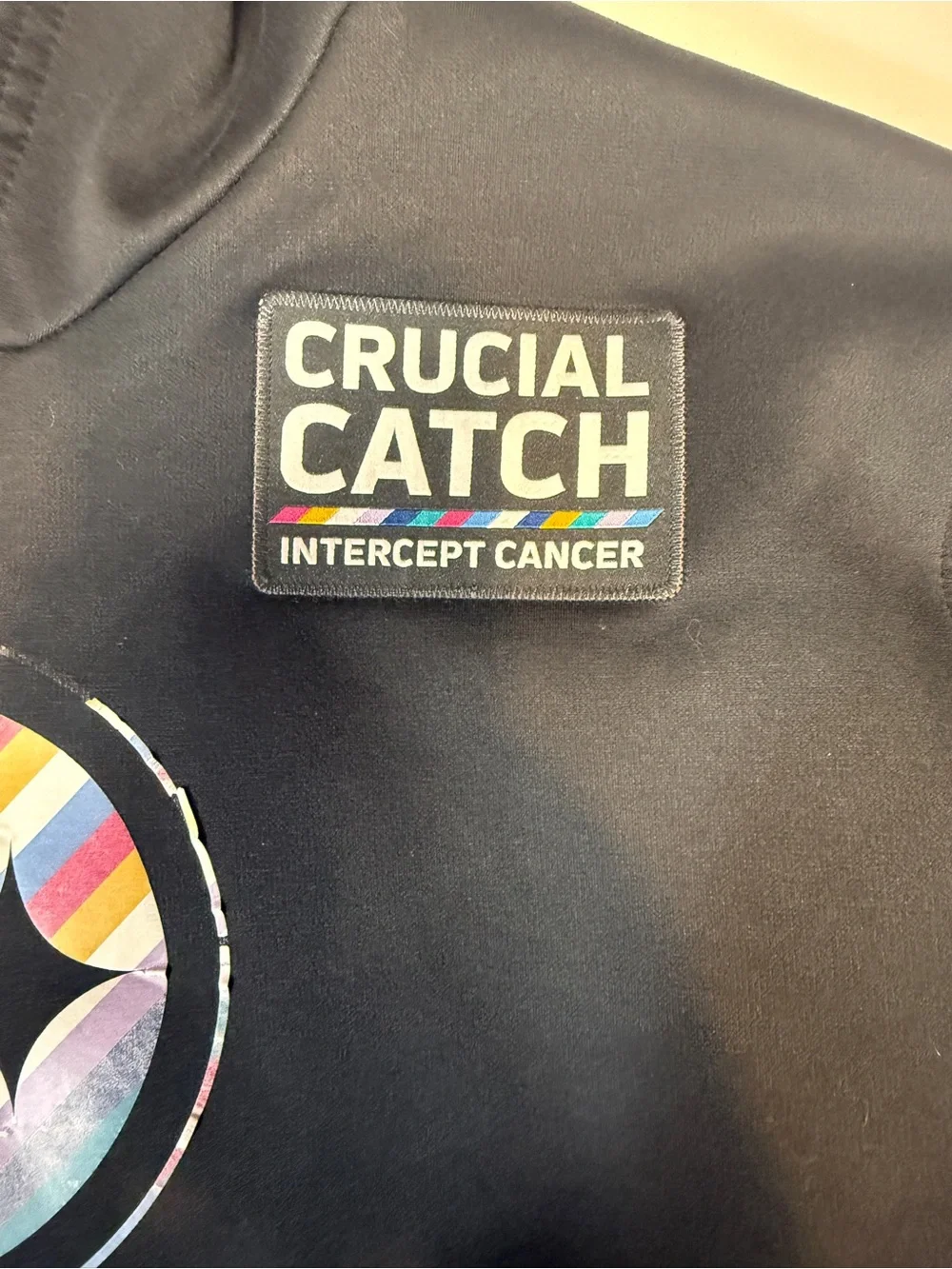Crucial Catch Black Pullover with Multicolor Stripe Patch